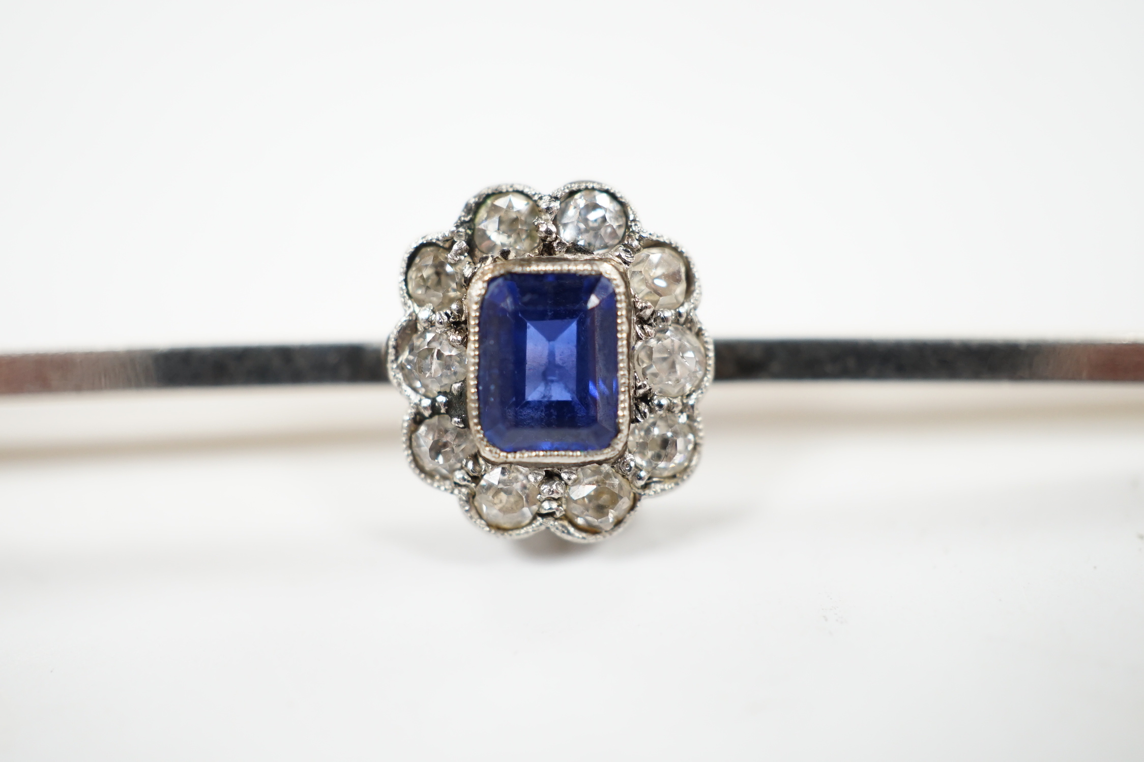 An early 20th century 15ct and plat, sapphire and diamond oval cluster set bar brooch, 64mm, gross weight 4.1 grams.